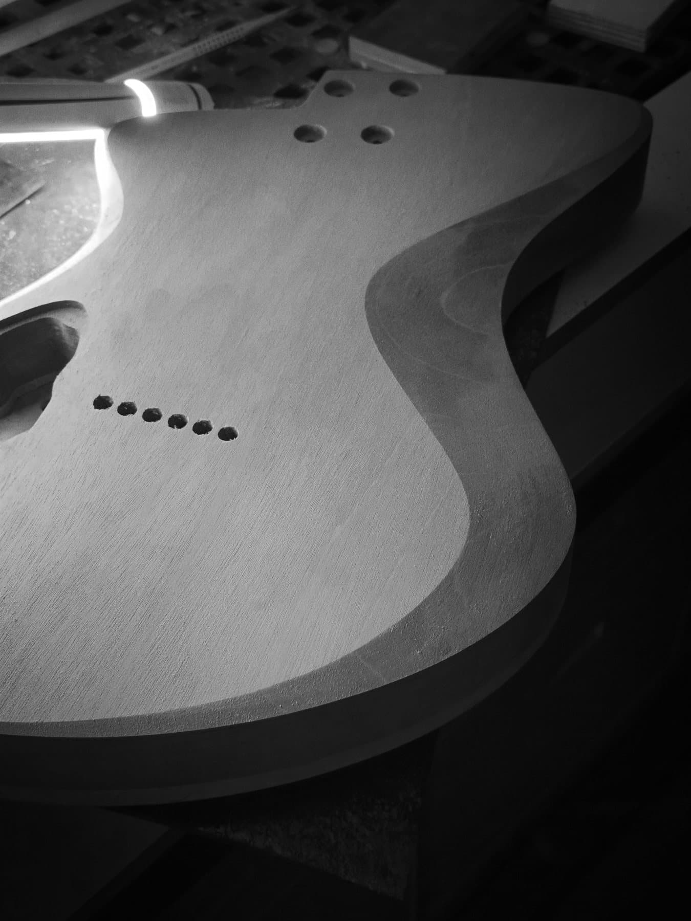 Detalhe das curvas de um corpo de guitarra, em preto e branco